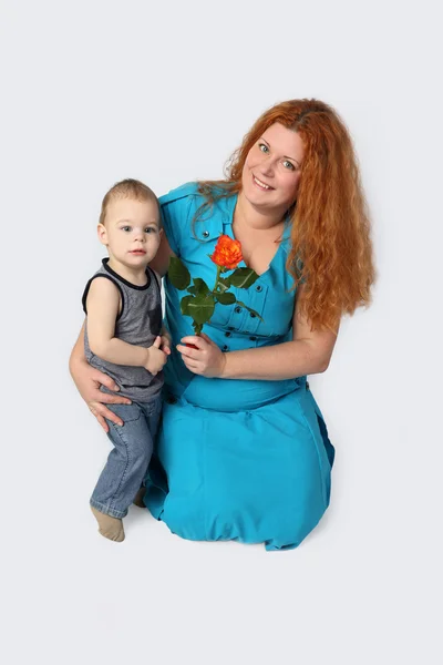 Happy redhead woman with little son and rose in hand — Stock Photo, Image