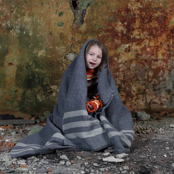 Kleines Mädchen sitzt in Decke gehüllt im Keller und weint — Stockfoto