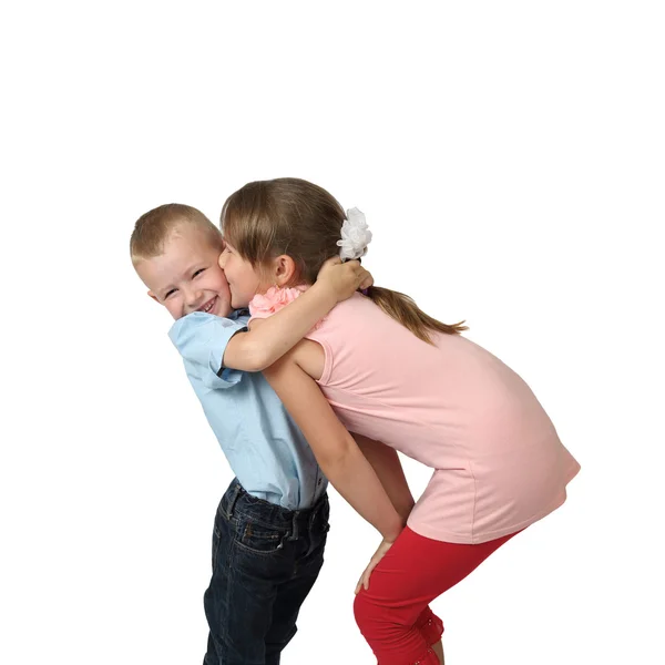 Girl kisses little boy on cheek Stock Image