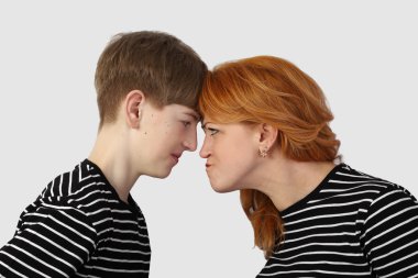 Woman and teenage boy resting heads against each other clipart