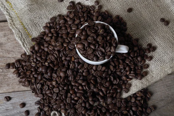 Coffee beans in cup on sackcloth — Stock fotografie