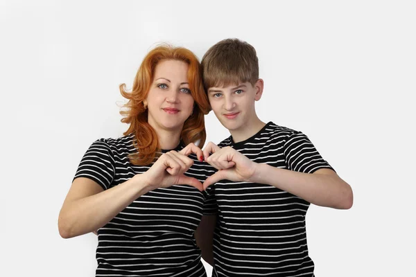 Madre e hijo muestran el corazón con los dedos en gris — Foto de Stock