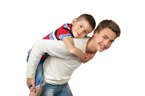 Older boy carries little brother on back — Stock Photo, Image