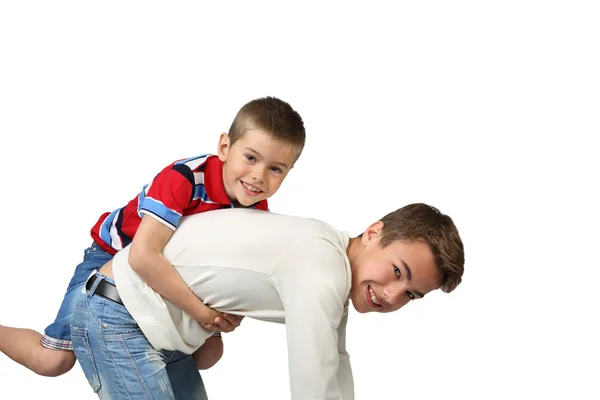 Older boy carries little brother on back — Stock Photo, Image