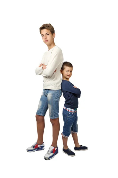 Tall teenager and little boy stand back to back — Stock Photo, Image