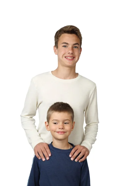 Teenage boys stands behind putting hands on his little brother — Stock Photo, Image
