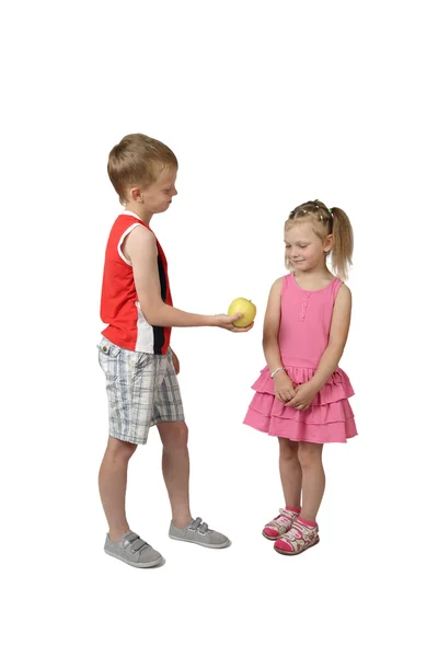 Little boy offers apple to girl — Stock fotografie