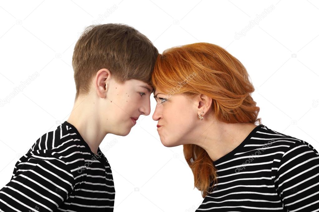 Woman and teenage boy resting heads against each other