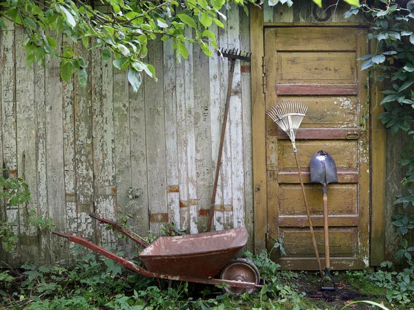 Garden tools leaning against wall of house — Stock Photo, Image