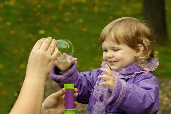 Маленькая девочка с мыльным пузырём — стоковое фото