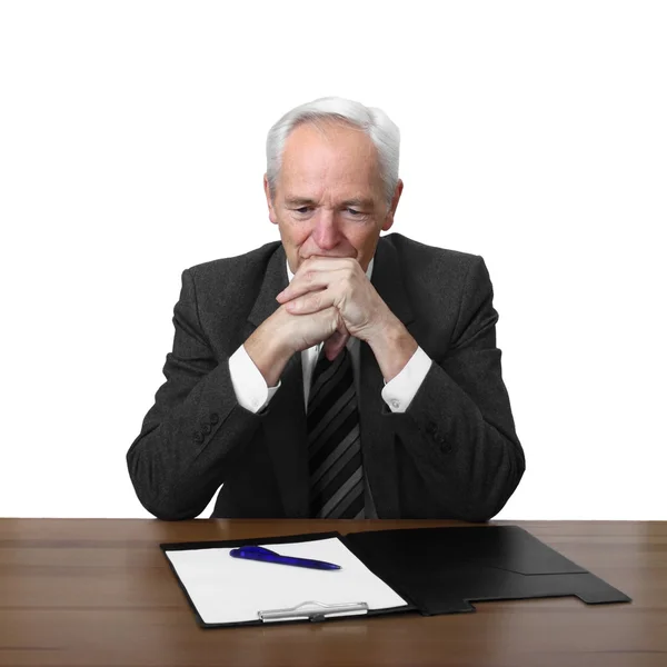 Senior man sits at table with document — Stock Photo, Image