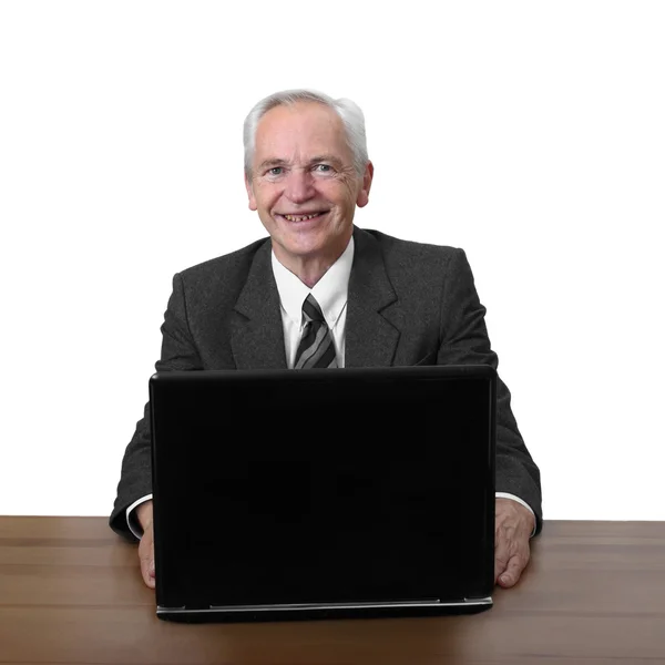 Senior man zit op laptop met glimlach — Stockfoto