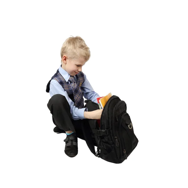 Schoolboy raccoglie schoolbag — Foto Stock
