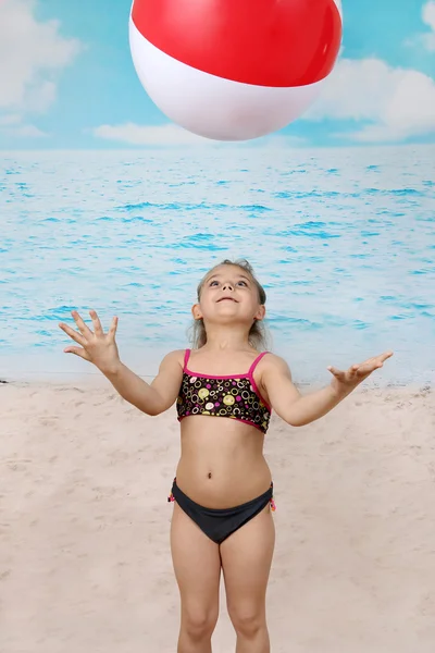 Милая маленькая девочка на пляже с мячом — стоковое фото