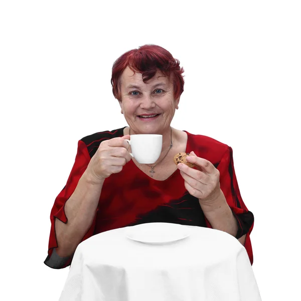 Senior woman with coffee cup and cookie — Stockfoto