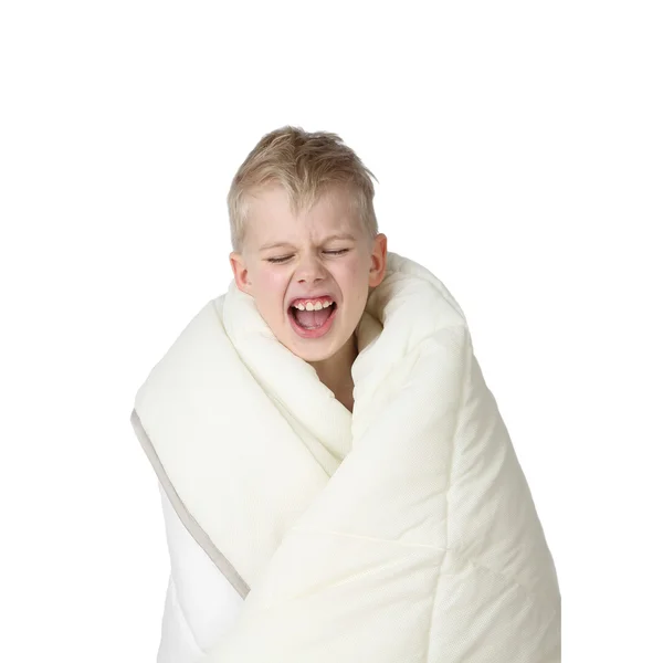 Cute little boy wrapped in blanket yawns ストックフォト