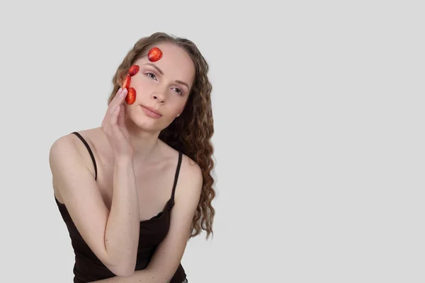 Young woman makes mask of strawberries — Stock Photo, Image