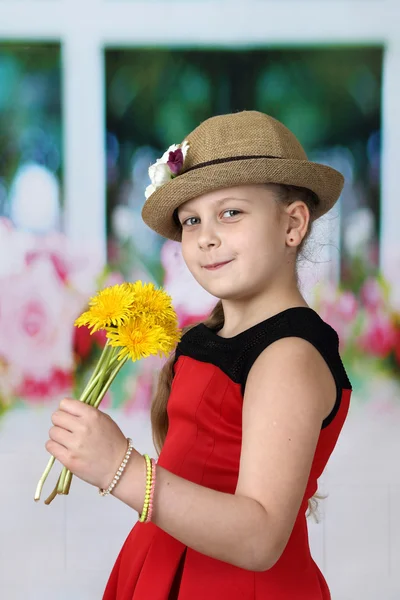 Pretty little girl in hat with dandelions in her hand — Stockfoto