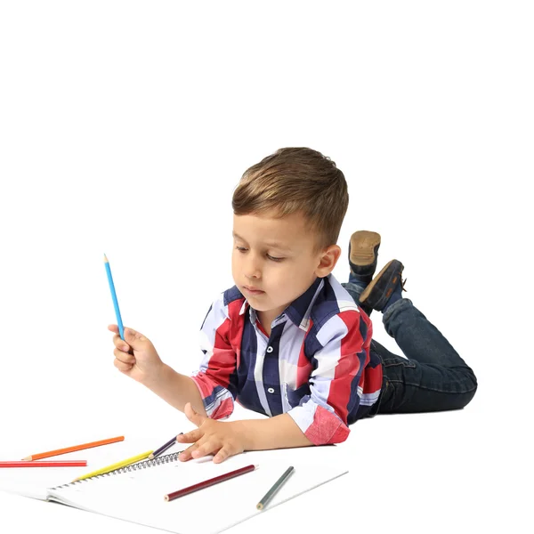 Маленький мальчик рисует лежа на полу — стоковое фото