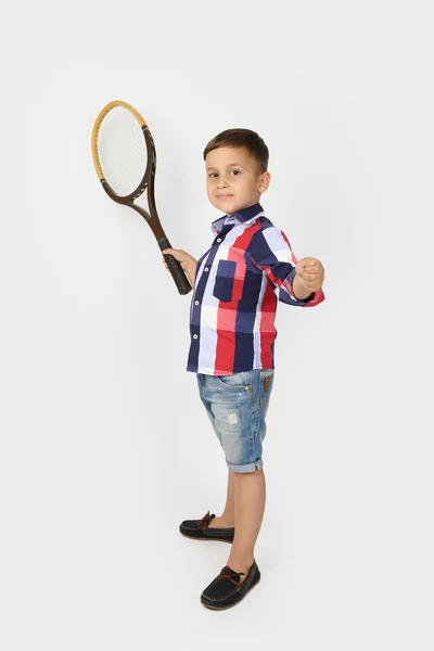 Little boy with tennis rackets on gray — Stockfoto