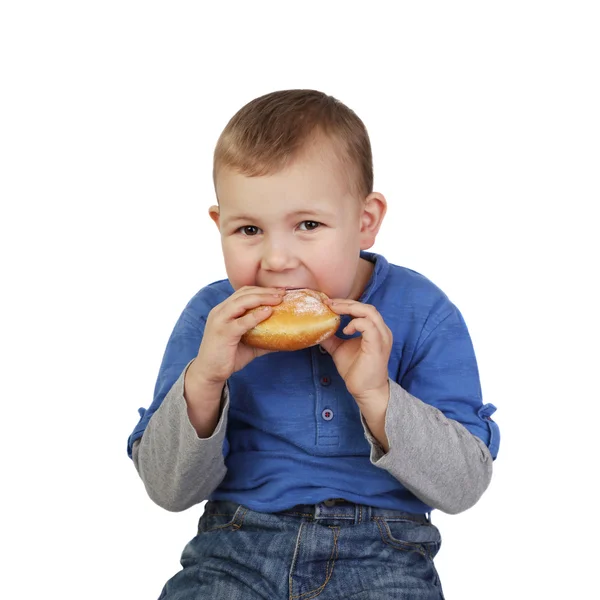 Little boy eats bun — Stock fotografie