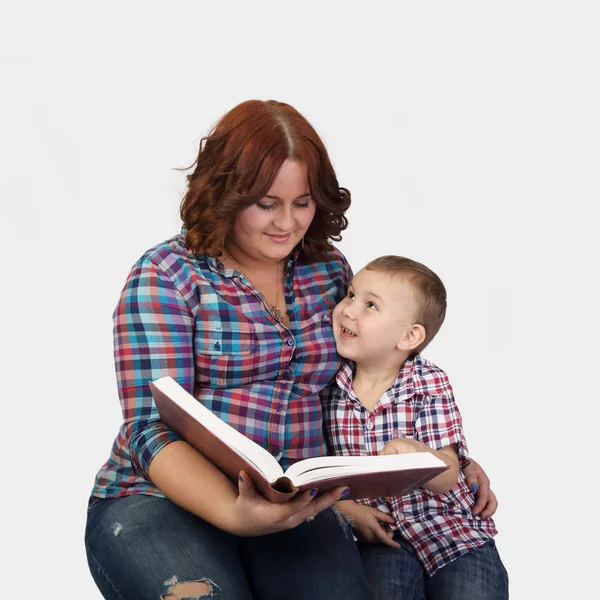Mother sits together with little son reading a big book — Stock Photo, Image