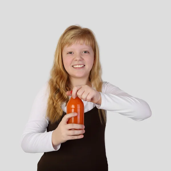 Teenage girl opens a bottle of carrot juice — Stock Photo, Image