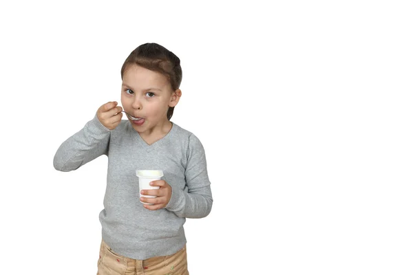 Meisje eet yoghurt geïsoleerd op witte achtergrond — Stockfoto