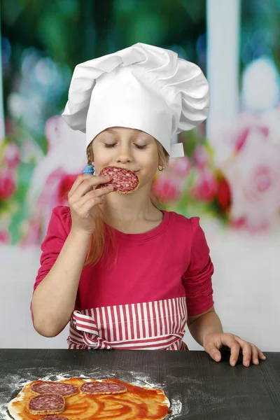 Young cook enjoys smell of sausage