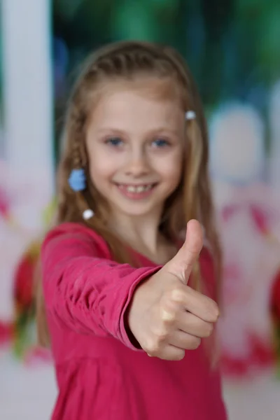 Schattig meisje toont grote vinger — Stockfoto
