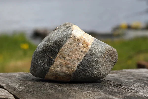 Prokládané kamenem na dřevěný stůl — Stock fotografie