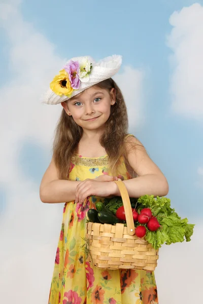 Cute little girl with basket of vegetables in hands — Stock Photo, Image