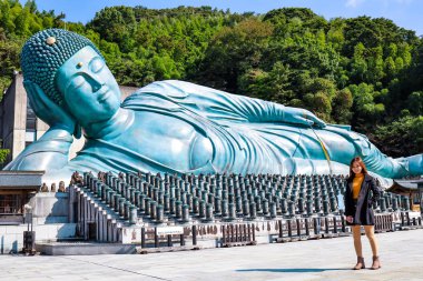 Japonya, Fukuoka Nanzo Tapınağı 'nda Büyük Buda' nın önünde güzel bir kız. Nanzoin, Sasaguri, Fukuoka Bölgesi, Japonya 'da bulunan bir Shingon mezhebidir..