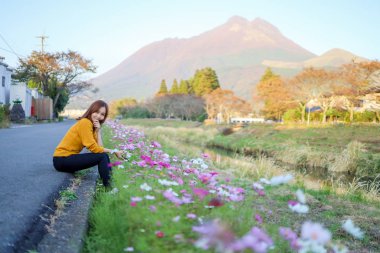 Japonya, Oita, Yufuin Kasabası 'ndaki gelincik tarlasında genç bir kadın.