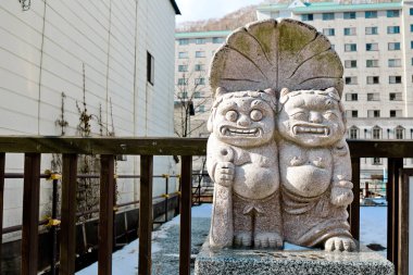 Hokkaido, Japonya - Aralık 2019: Jigokudani 'nin önündeki dev heykel veya Noboribetsu Onsen kasabasındaki Hell Valley bölgesi. Noboribetsu 'da çok çekici buhar bacaları, sülfürlü akarsu var.