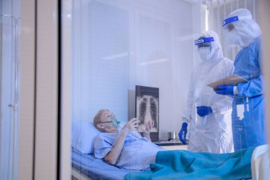 Karantinada karantinada karantinada yatan ve Coronavirus covid 19 hastalığından yatağında yatan doktor ve hemşirenin bakımıyla enfekte olmuş hasta. Covid19 veya corona virüsü dünya çapında sosyal bir konsepttir..