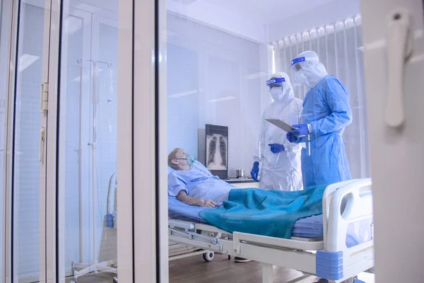 Karantinada karantinada karantinada yatan ve Coronavirus covid 19 hastalığından yatağında yatan doktor ve hemşirenin bakımıyla enfekte olmuş hasta. Covid19 veya corona virüsü dünya çapında sosyal bir konsepttir..
