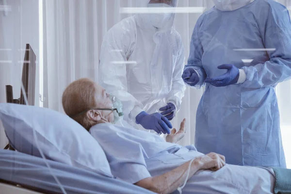 Karantinada karantinada karantinada yatan ve Coronavirus covid 19 hastalığından yatağında yatan doktor ve hemşirenin bakımıyla enfekte olmuş hasta. Covid19 veya corona virüsü dünya çapında sosyal bir konsepttir..