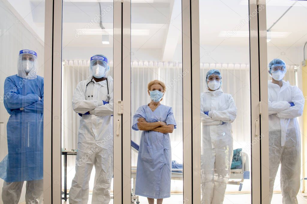 Dortor, Nurse and patient looking out in the quarantine room from case of coronavirus covid 19. Virus infected patient with outbreak at hospital with coronavirus covid 19 disease treatment.