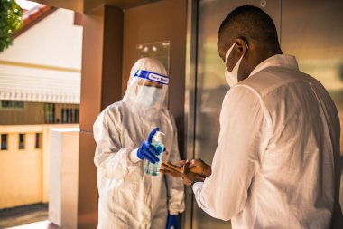 Ofiste, Novel Coronavirus ya da Corona Virüs Hastalığı (Covid-19) ile mücadele etmek için, insanlara el yıkama jeli ile jel sıkmak. Antiseptik, Hijyen ve Sağlık Konsepti