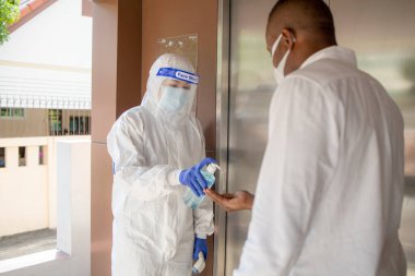 Ofiste, Novel Coronavirus ya da Corona Virüs Hastalığı (Covid-19) ile mücadele etmek için, insanlara el yıkama jeli ile jel sıkmak. Antiseptik, Hijyen ve Sağlık Konsepti