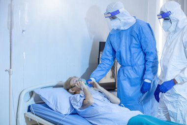 Hastane karantina odasındaki yatakta yatarken enfeksiyon kapmış 19 hastaya doktor ve hemşire bakıyor. Coronavirus covid 19 hastalığı. Corona virüsü dünya çapında sosyal bir sorundur.
