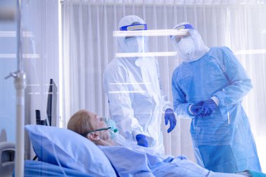 Hastane karantina odasındaki yatakta yatarken enfeksiyon kapmış 19 hastaya doktor ve hemşire bakıyor. Coronavirus covid 19 hastalığı. Corona virüsü dünya çapında sosyal bir sorundur.
