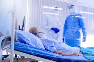 Hastane karantina odasındaki yatakta yatarken enfeksiyon kapmış 19 hastaya doktor ve hemşire bakıyor. Coronavirus covid 19 hastalığı. Corona virüsü dünya çapında sosyal bir sorundur.