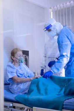 Hastalıklı hastayla ilgilenen hemşire hastanede yatıyor ve doktorla ilgileniyor. Karantina odasında akciğer röntgeni. Coronavirus covid 19 hastalığı vakası..
