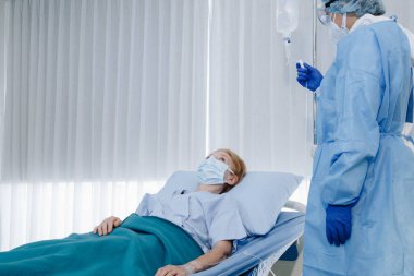 Sağlık ekibi Coronavirus covid 19 enfeksiyonlu yaşlı kadın hastalara daha iyi semptomlar gösterip tedavi etmeye çalışıyor..
