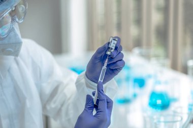 COVID19, Coronavirus ya da Roman Corona salgını için kan testi tüpüne odaklanın. PPE 'deki laboratuvar teknisyeni. Kişisel Koruyucu Ekipman. Hastane laboratuvarında kan tüpü testi yapıyorlar..