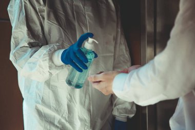 Ofiste, Novel Coronavirus ya da Corona Virüs Hastalığı (Covid-19) ile mücadele etmek için, insanlara el yıkama jeli ile jel sıkmak. Antiseptik, Hijyen ve Sağlık Konsepti