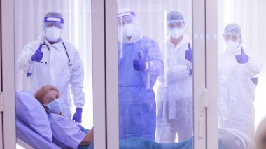 Doktor ve hemşire ekibinin zaferi hastayı hastaneden kurtardı. İyileşen hasta ve tıbbi ekip Covid-19 salgınını kazandı. Sağlık Sigortası, mutlu hasta, takım çalışması, el çabukluğu kavramını yükseltin