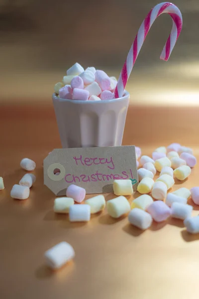 Frohe Weihnachten Handschrift und eine Tasse voller bunter Marshmall — Stockfoto